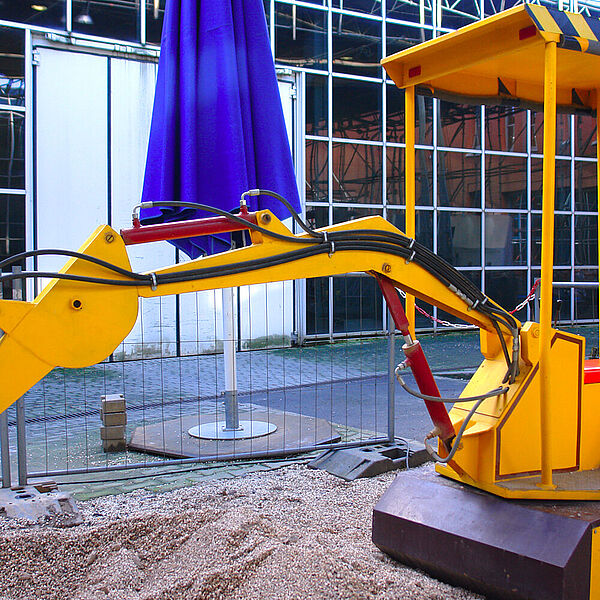Ein Kinderbagger als Exponat auf der Baustelle der DASA