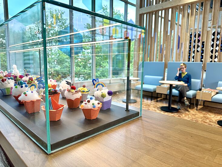 Eine Vitrine gefüllt mit gebastelten Cupcakes in der Ausstellung Dienstleistung in der DASA