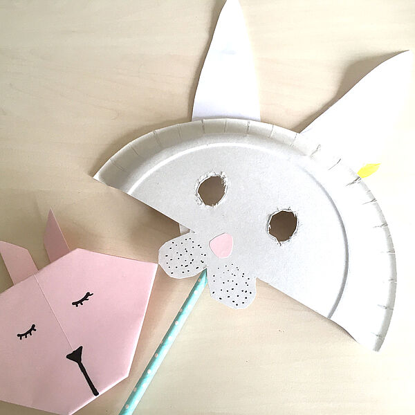 Hasenmaske die aus einem Pappteller und einem Strohhalm gebastelt wurde.