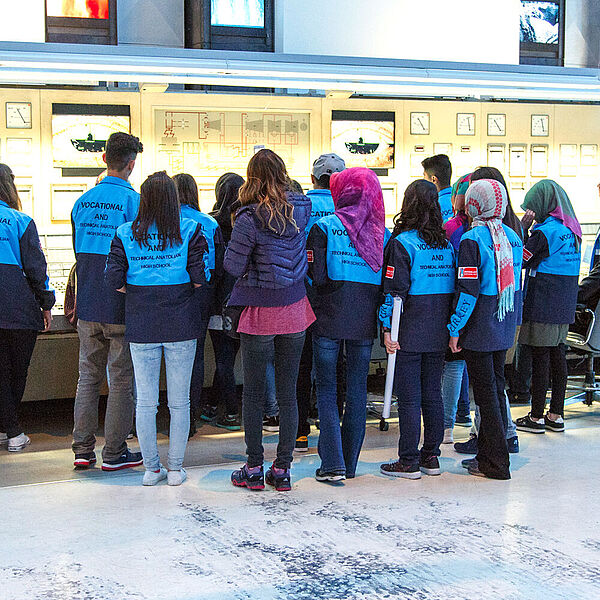 Eine Gruppe ausländischer Jugendlicher erhalten eine Führung in der Energiehalle