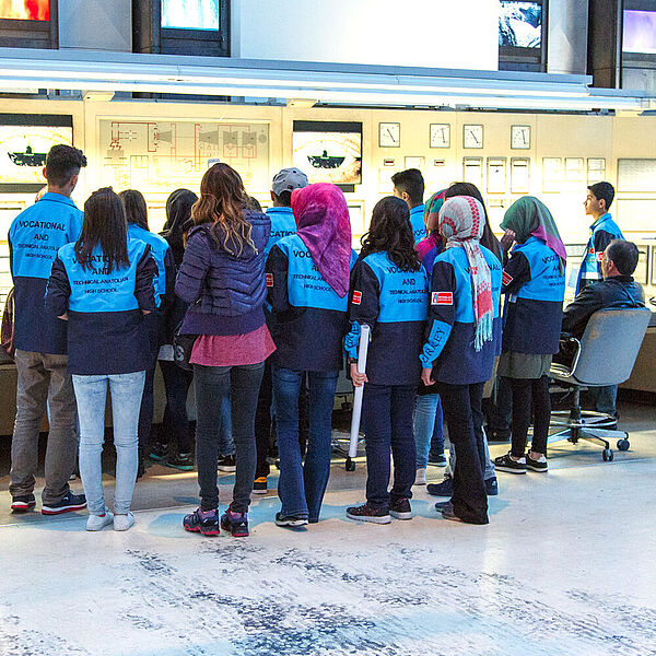 Eine Gruppe ausländischer Jugendlicher erhalten eine Führung in der Energiehalle