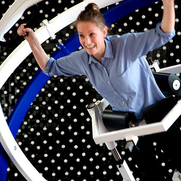 Besucherin probiert das Space Curl in der DASA