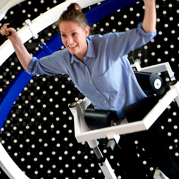Besucherin probiert das Space Curl in der DASA
