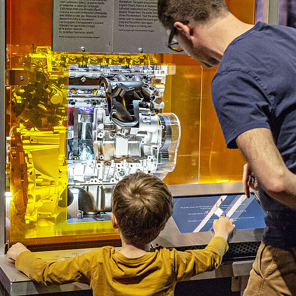 Ein Vater erkl&auml;rt seinem Sohn ein Exponat in der Ausstellung Feuer.