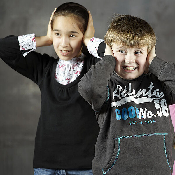 Kinder halten sich die Ohren zu