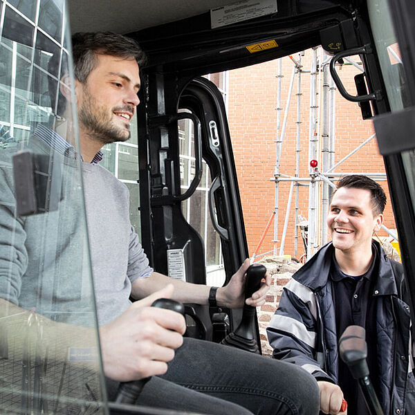 Junger Mann im Mini-Bagger der DASA mit Vorführtechniker