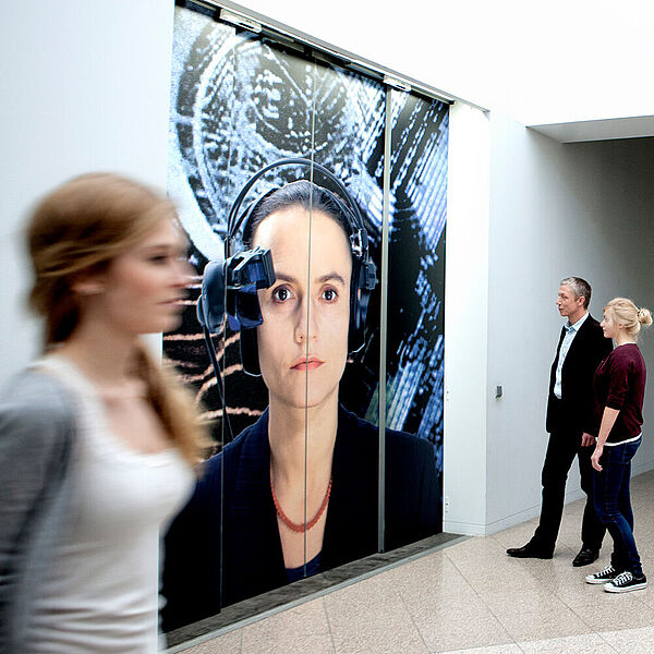 Besucherin in der DASA läuft an einem grossen Wandbild vorbei.