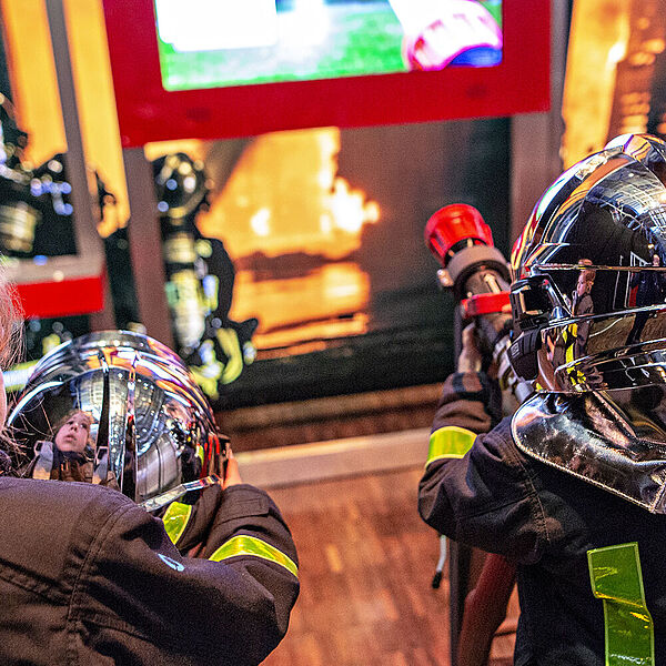 Kinder erkunden ein Spiel in der Ausstellung Feuer.