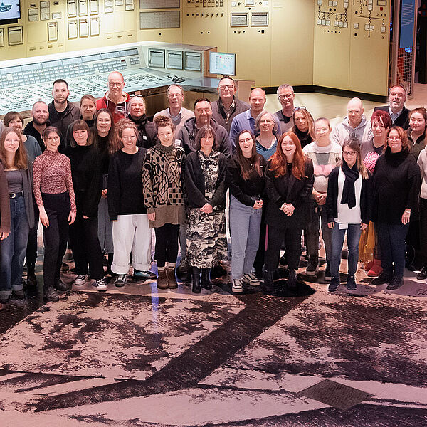 Das Team der DASA steht in einem Halbkreis in der Energiehalle der DASA