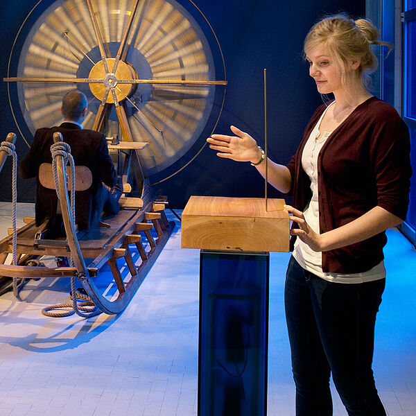 Besucherin testet ein elektrisch aufgeladenes Objekt in der DASA