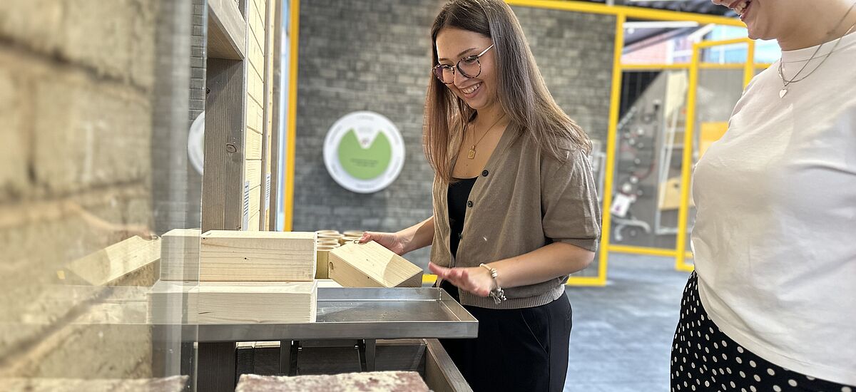 Baustoffe Zwei Frauen schauen sich neue Baustoffe, etwa aus Pilzen, an.
