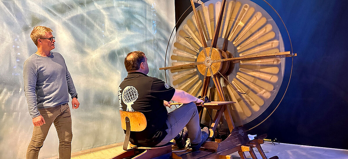 Eine künstlerische Installation auf der man rudert und dabei Funken schlägt