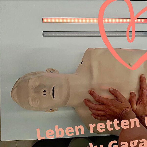 Übungspuppe an der Herzdruckmassage geübt werden kann.