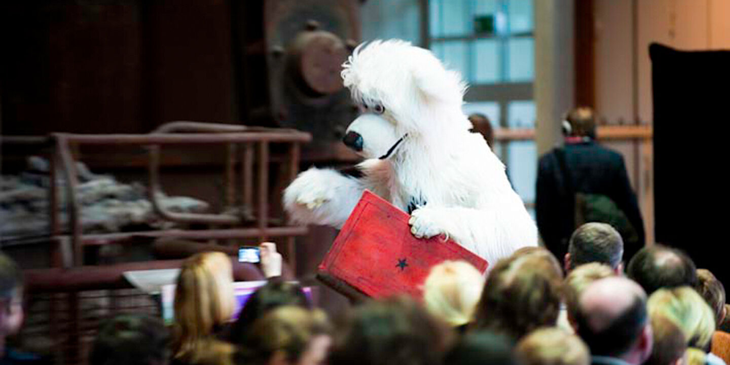 Als Hund kostumierter Darsteller läuft über eine Bühne beim Aktionstag in der DASA