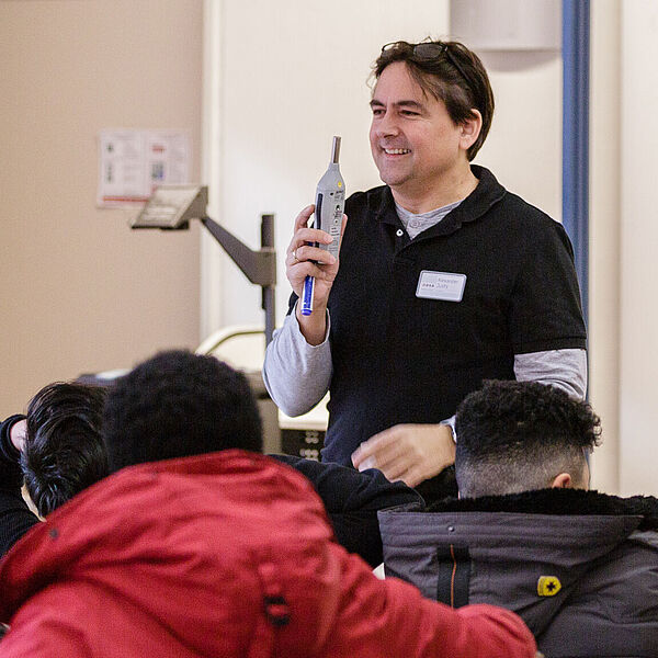 Lehrer steht vor Schülern des Seminars für Arbeits- und Wirtschaftserziehung