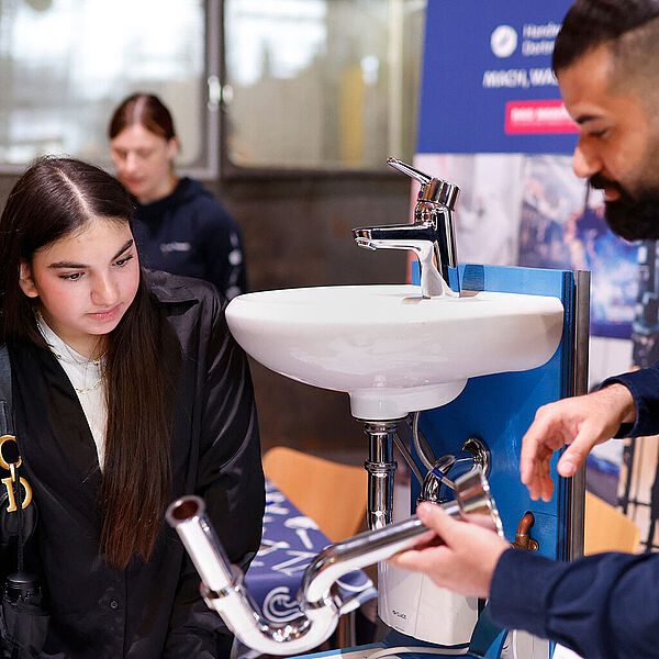 Standbetreuer erkl&auml;rt 2 M&auml;dchen eine Rohrverbindung