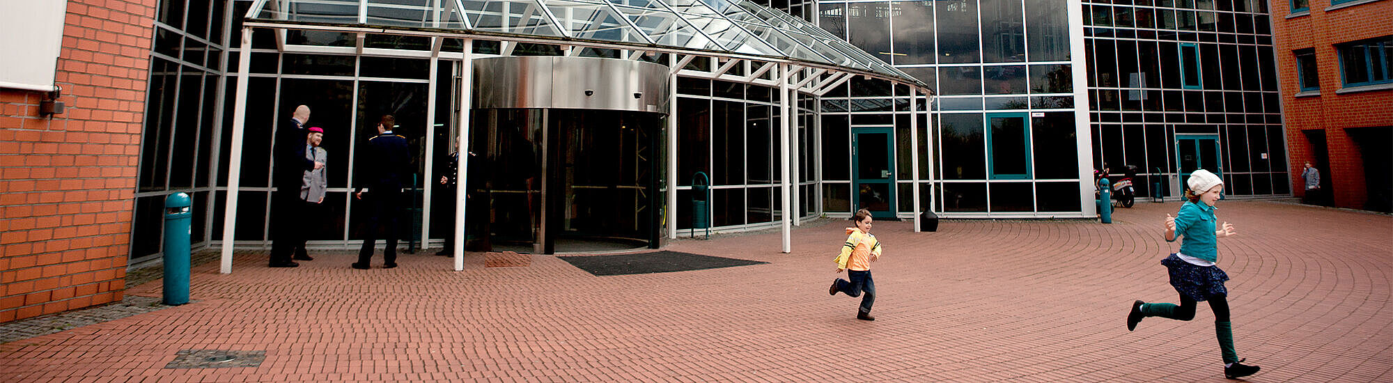 Kinder laufen vor dem Eingangsbereich der DASA