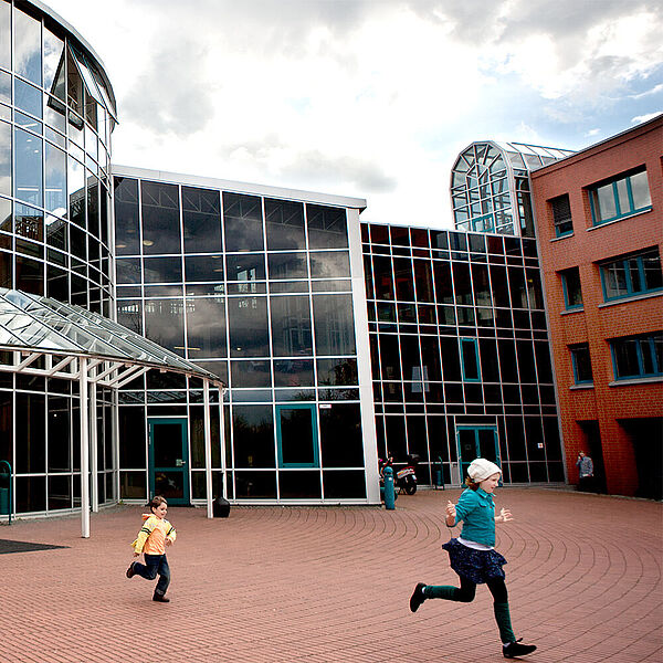 Kinder laufen vor dem Eingangsbereich der DASA