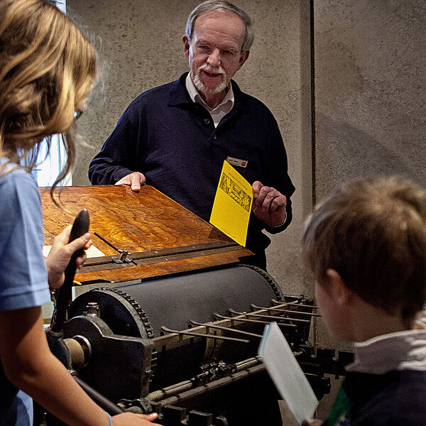 Vorführtechniker in der DASA an der Druckpresse für Postkarten