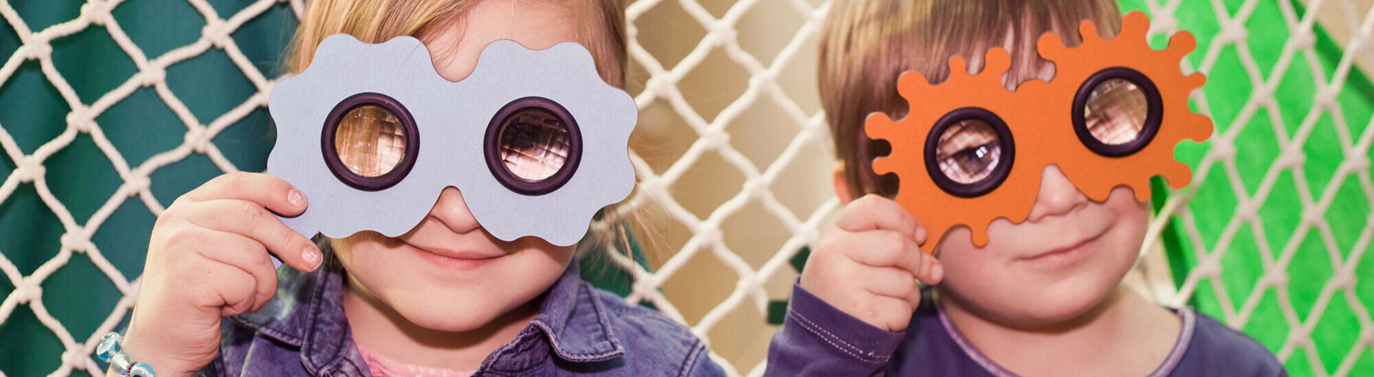 Kinder schauen durch eine Brille mit Insektenaugen