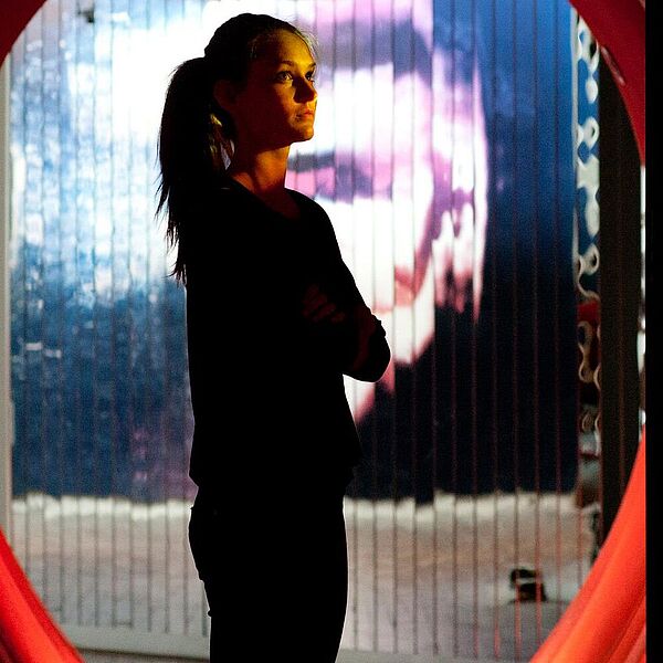 Besucherin steht im Lärmtunnel und betrachtet die Wandinstallation