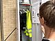 Kleidung schützt Frau schaut in ein Spind mit wetterfester Kleidung in der Ausstellung Hochbau.