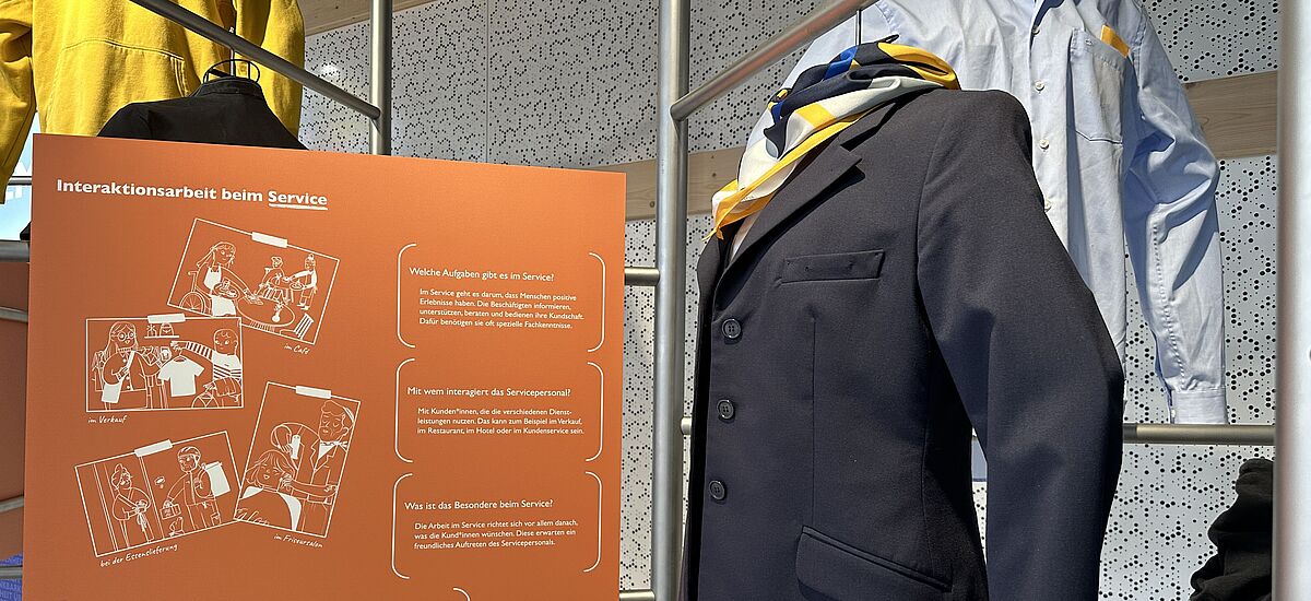 Dienstkleidung Kleiderstangen mit Dienstkleidung, etwa von einer Stewardess in der Ausstellung Dienstleistung