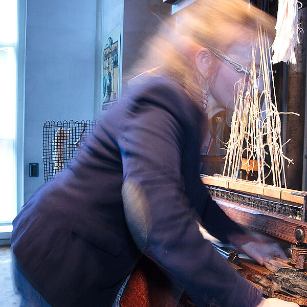 Frau arbeitet an den DASA-Webstühlen