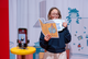 Einschlafen Frau hat eine große Teetasse und ein Buch in der Hand, davor ist ein Handy zu sehen. Das ist ein Selfie-SPot in der Ausstellung "GUte Nacht".