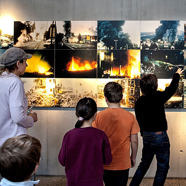 Schülerinne und Schüler schauen sich Fotos vom Unglück in Herborn an.